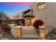 Ornate home entrance with brick pathway and red flowers at dusk at 15419 E Stardust Dr, Fountain Hills, AZ 85268