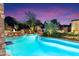Expansive pool and spa with a rock waterfall, beautifully illuminated at night at 15419 E Stardust Dr, Fountain Hills, AZ 85268
