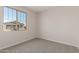 Simple bedroom with grey carpet and a window at 21615 N Daniel Dr, Maricopa, AZ 85138