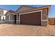 House exterior showcasing a two-car garage and a brick paved driveway at 21615 N Daniel Dr, Maricopa, AZ 85138