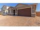 House exterior with a two-car garage and a brick paved driveway at 21615 N Daniel Dr, Maricopa, AZ 85138
