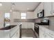 Modern kitchen with white cabinets, stainless steel appliances, and quartz countertops at 21615 N Daniel Dr, Maricopa, AZ 85138