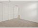This bedroom features neutral carpet, white walls, and closet with sliding doors at 22489 W Pontiac Dr, Surprise, AZ 85387