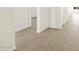 Bright hallway featuring wood-look flooring and white walls, offering a modern aesthetic at 22489 W Pontiac Dr, Surprise, AZ 85387