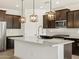 Modern kitchen featuring granite countertops, dark wood cabinets, and stainless steel appliances at 22489 W Pontiac Dr, Surprise, AZ 85387
