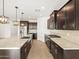 Modern kitchen featuring granite countertops, dark wood cabinets, and stainless steel appliances at 22489 W Pontiac Dr, Surprise, AZ 85387