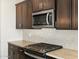 Modern kitchen featuring granite countertops, dark wood cabinets, and stainless steel appliances at 22489 W Pontiac Dr, Surprise, AZ 85387