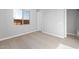 An interior view of a bedroom with carpet flooring, window and a door to the next room at 24691 N 169Th Ave, Surprise, AZ 85387