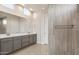Bathroom features a dual vanity with gray cabinets, a large mirror, and a glass-enclosed tiled shower at 24707 N 169Th Ave, Surprise, AZ 85387