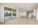 Spacious living area with tile flooring, connecting seamlessly to the outdoors through sliding glass doors and open to kitchen at 24707 N 169Th Ave, Surprise, AZ 85387