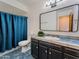 Traditional bathroom with blue tile counters, black cabinets, and shower with a blue curtain at 2804 W Curry St, Chandler, AZ 85224