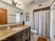 Bathroom featuring granite counters, dark cabinets, and shower with a white curtain at 2804 W Curry St, Chandler, AZ 85224