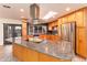 This spacious kitchen includes an island with granite countertops, a skylight and stainless steel appliances at 2804 W Curry St, Chandler, AZ 85224