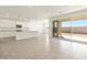 Well-lit kitchen featuring white cabinets, a granite island and sliding glass doors at 37013 W La Paz St, Maricopa, AZ 85138