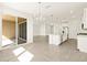 Open-concept living area with tile flooring, a modern island, and sliding glass doors at 37013 W La Paz St, Maricopa, AZ 85138