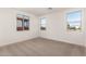 Spacious bedroom with neutral carpet and large windows at 40548 W Wade Dr, Maricopa, AZ 85138