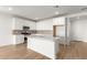 Open concept kitchen with island, white cabinets, and stainless steel appliances at 40548 W Wade Dr, Maricopa, AZ 85138