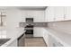 Modern kitchen with white cabinets, quartz countertops, and stainless steel appliances at 40548 W Wade Dr, Maricopa, AZ 85138