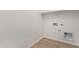 Bright laundry room with wood-look flooring and built-in shelving at 40548 W Wade Dr, Maricopa, AZ 85138