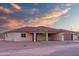 Beautiful single-story home with a large garage and a tile roof, set against a vibrant sunset sky at 115 Ironwood Pl, Wickenburg, AZ 85390