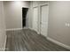 Hallway featuring wood-style floors and white trim, with doors leading to other rooms at 1406 W Main St # 140, Mesa, AZ 85201