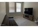 Cozy living room with futon, TV, and large windows at 1406 W Main St # 140, Mesa, AZ 85201
