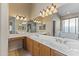 Well-lit bathroom featuring dual sinks, vanity area, large mirrors, and a separate tub enclosure at 14430 N Prickly Pear Ct, Fountain Hills, AZ 85268