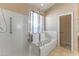Bathroom featuring a large bathtub with a glass door and neutral tile flooring at 14430 N Prickly Pear Ct, Fountain Hills, AZ 85268