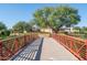 Red metal bridge leading into a community with lush landscaping at 16731 S 181St Ave, Goodyear, AZ 85338