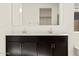 Close-up of the double vanity, large mirror and white countertops in the bathroom complemented by natural light at 22507 W Pontiac Dr, Surprise, AZ 85387