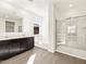 This bathroom features a double vanity, soaking tub, and separate shower with glass doors and tile surround at 22507 W Pontiac Dr, Surprise, AZ 85387