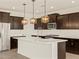 Modern kitchen featuring an island with pendant lights, sleek white countertops, and stainless steel appliances at 22507 W Pontiac Dr, Surprise, AZ 85387