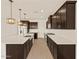 Bright and spacious kitchen with an expansive island, dark wood cabinets, and stainless steel appliances at 22507 W Pontiac Dr, Surprise, AZ 85387