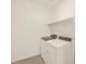 Functional laundry room featuring a modern washer and dryer with storage shelving at 22507 W Pontiac Dr, Surprise, AZ 85387