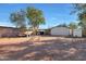 Large backyard with gravel ground cover, soccer goal, shed, and mature trees at 3206 W Garfield St, Phoenix, AZ 85009