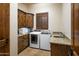 Laundry room with wooden cabinets, granite countertop, and a washer and dryer at 7624 E Stagecoach Pass, Carefree, AZ 85377