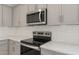 Stainless steel appliances and gray cabinets in modern kitchen at 17819 W Encinas Ln, Goodyear, AZ 85338