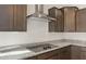 Modern kitchen features dark wood cabinets, granite countertops, and a stainless steel range hood at 17867 W Encinas Ln, Goodyear, AZ 85338