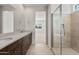 Bathroom with double vanity, shower, and view into bedroom at 17869 W Getty Dr, Goodyear, AZ 85338