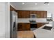 Modern kitchen featuring dark wood cabinets, stainless steel appliances, and white subway tile at 17869 W Getty Dr, Goodyear, AZ 85338
