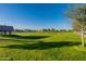 Lush green lawn with trees and seating area for residents to enjoy within the well-maintained community at 20698 E Marsh Rd, Queen Creek, AZ 85142