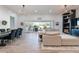 Bright open-concept living room featuring modern light fixtures and a sliding glass door to the patio at 20698 E Marsh Rd, Queen Creek, AZ 85142