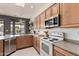 Well-lit kitchen with wooden cabinets, stainless steel appliances, tile flooring, and a large sink under a window at 22213 W Patton Rd, Wittmann, AZ 85361