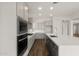Modern kitchen with stainless steel appliances, gray cabinetry, an island, and wood-look tile flooring at 22500 E Orchard Ln, Queen Creek, AZ 85142