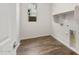 Functional laundry room features wood-look tile floors and washer/dryer hookups at 22500 E Orchard Ln, Queen Creek, AZ 85142