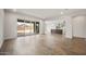 Spacious living room with wood-look floors and backyard views, next to the kitchen area at 22500 E Orchard Ln, Queen Creek, AZ 85142
