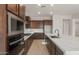 Modern kitchen with stainless steel oven, microwave, stylish countertop, and dark wood cabinetry at 22536 E San Tan Blvd, Queen Creek, AZ 85142