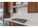 Close-up of the stainless steel gas cooktop and range hood, with subway tile backsplash and dark cabinets at 22536 E San Tan Blvd, Queen Creek, AZ 85142