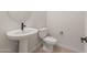 Neat powder room featuring a modern pedestal sink, a toilet, and fixtures, perfect for guests' convenience at 22536 E San Tan Blvd, Queen Creek, AZ 85142
