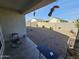 Covered patio with rocking chair and small table, overlooking a gravel backyard at 44394 W Palo Aliso Way, Maricopa, AZ 85138